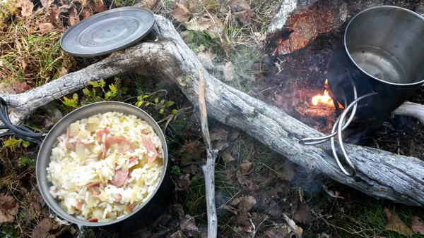 töpfe auf waldboden und feuer